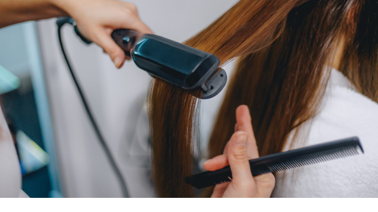 ヘアアイロンをかける女性